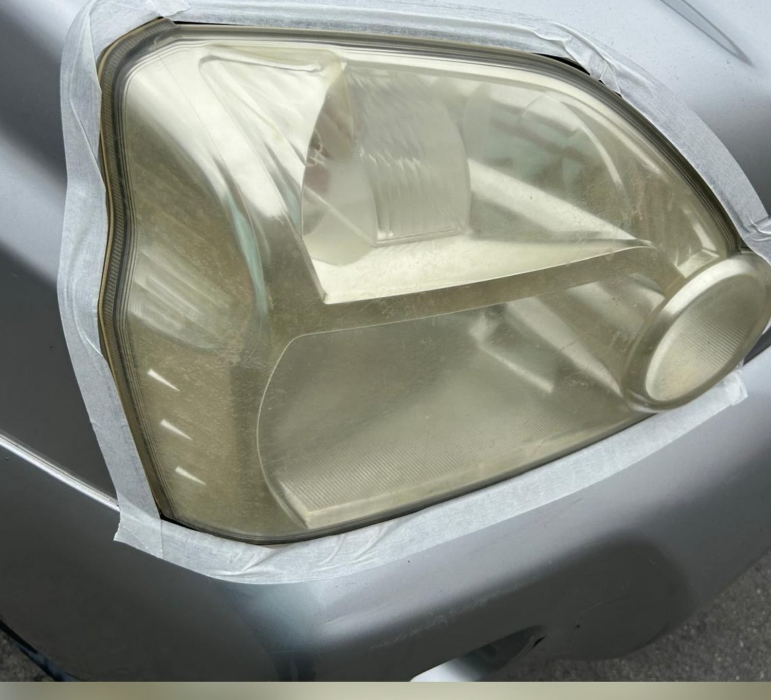 Nissan X-Trail headlight before restoration — heavily yellowed and foggy
